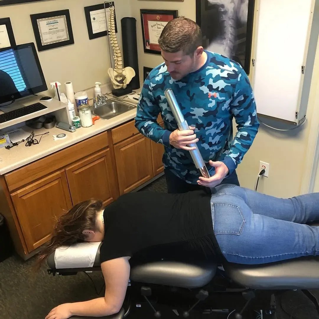 Dr. Adam Evans treating a patient with instrument-assisted soft tissue work