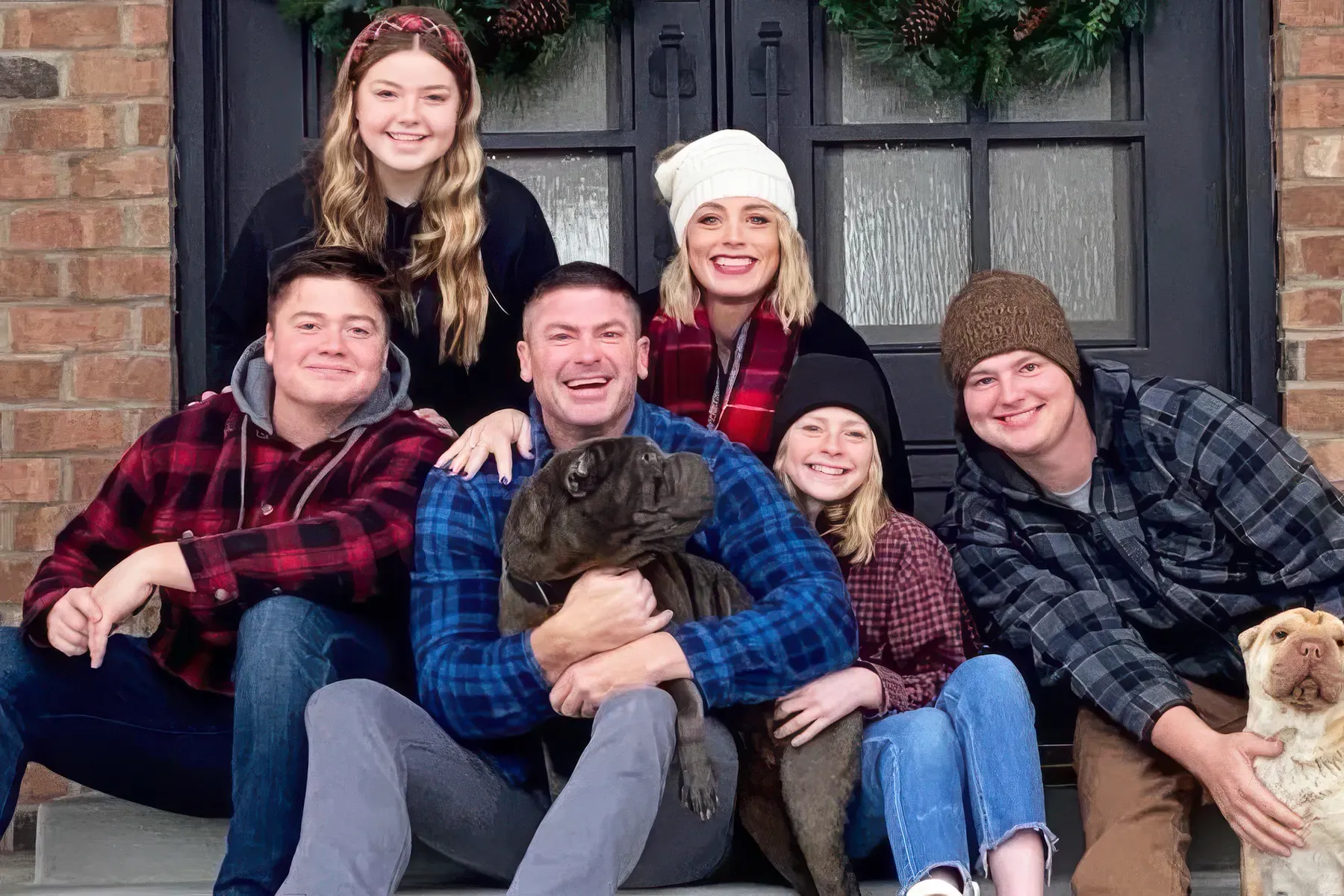 Dr. Adam Evans with his wife, their four kids, and the family dogs on their front porch